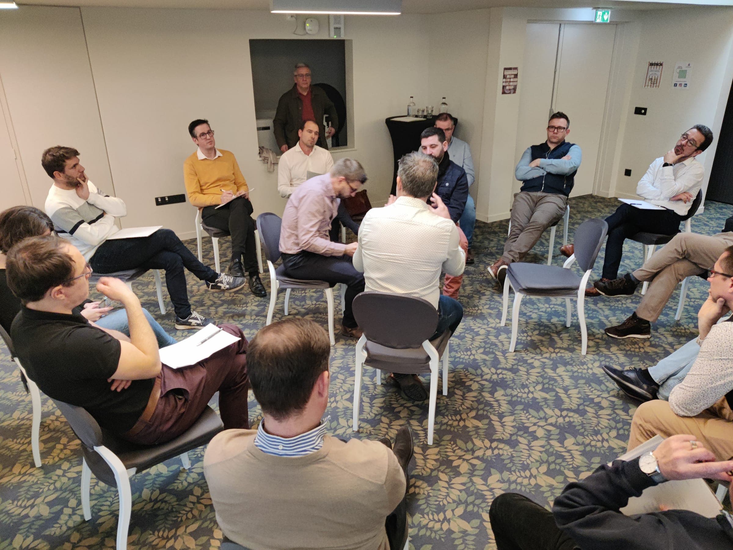Une douzaine de personnes assises en cercle échangent pendant un atelier